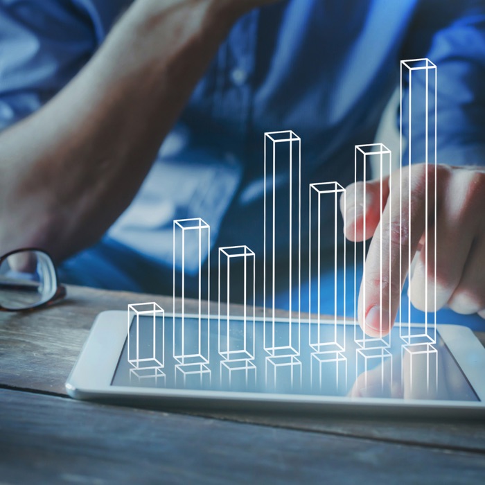 A rising bar chart above a tablet